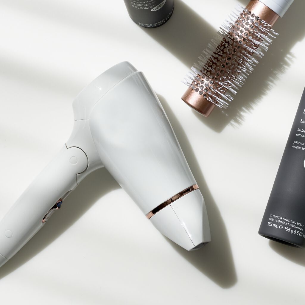 white blow dryer and round brush