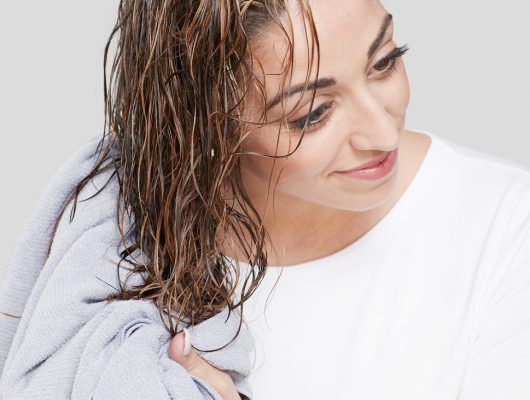 woman drying hair with a towel