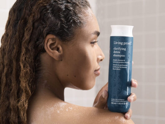 woman holding clarifying detox shampoo in the shower