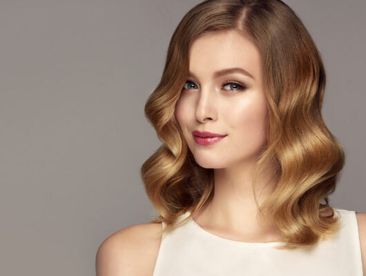 Woman with glossy, wavy hair showcasing the results of a healthy hair routine without silicone-based products
