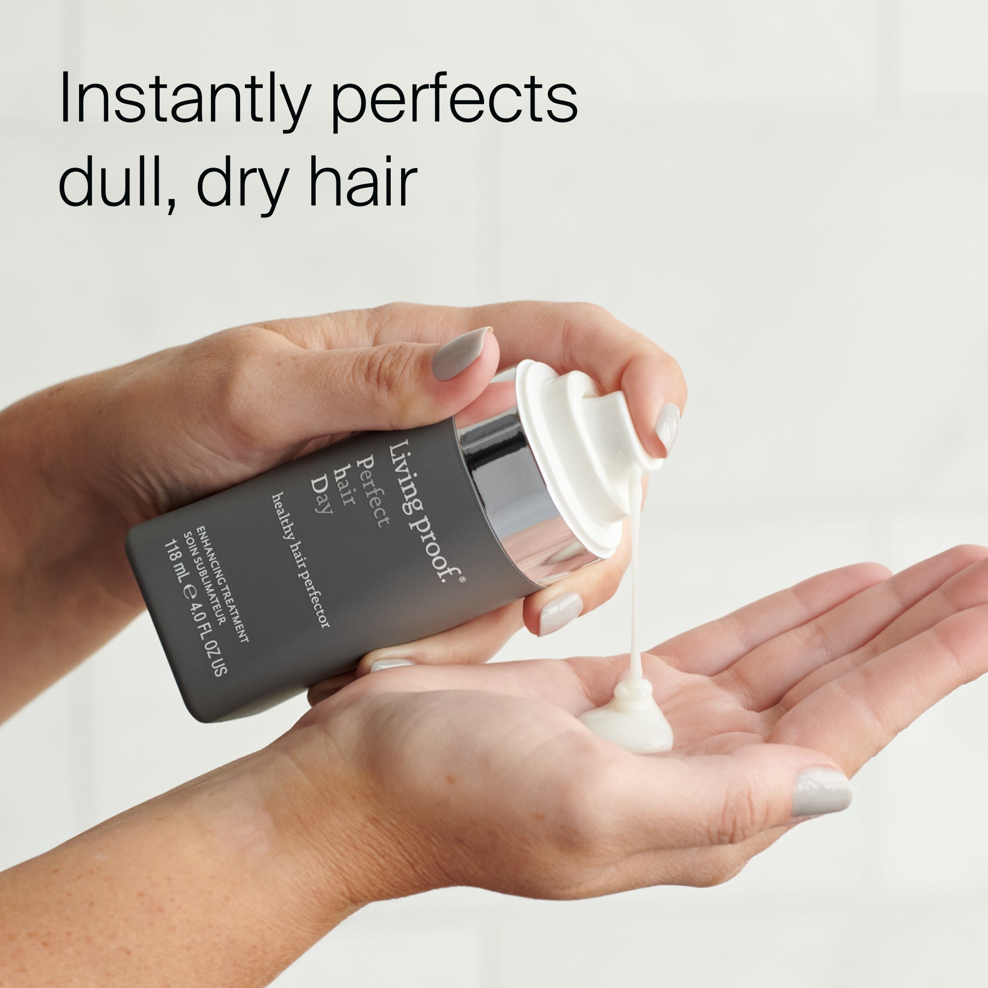 A hand holds a Perfect hair Day™ Healthy Hair Perfector bottle while another dispenses white cream, with the text Instantly perfects dull, damaged hair for healthier-looking hair above.