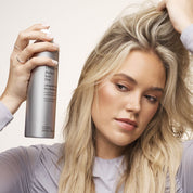 Model spraying Perfect hair Day Advanced Clean Dry Shampoo in dirty hair