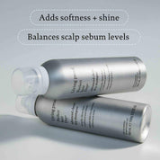 Two silver cans of Perfect hair Day™ Advanced Clean Dry Shampoo are stacked on a light surface, with text above reading: Adds just-washed softness & shine and Balances scalp sebum levels with a breakthrough formula.