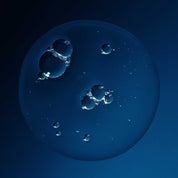 A cluster of clear bubbles floats against a dark blue backdrop, their shiny surfaces reflecting light and evoking the weightless volume achieved with Full Voluminous Hair Essentials.