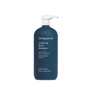 A dark blue 710 mL (24 fl. oz) bottle of Clarifying Detox Shampoo with a white pump dispenser; the white label shows the product name and description. This shampoo removes buildup, making it ideal for hard water users.