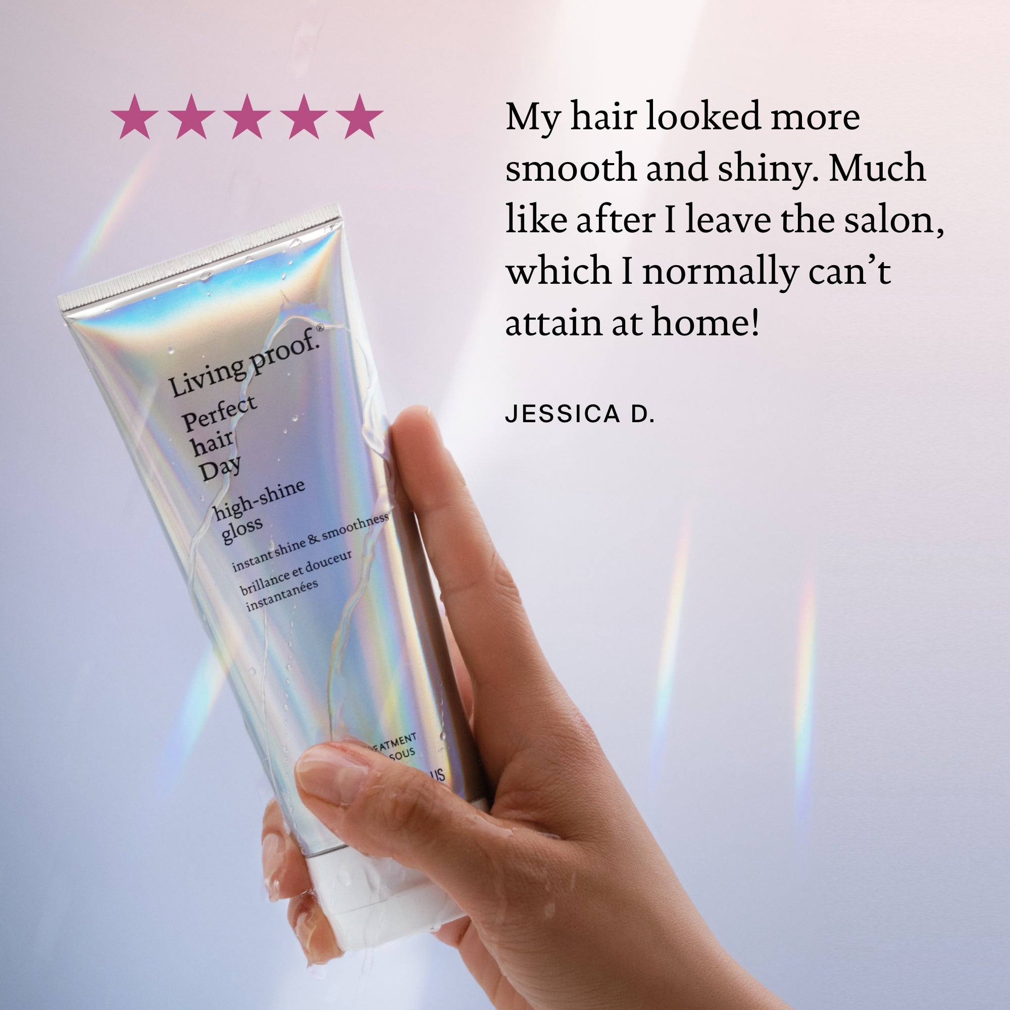A hand holds a tube of Curl Curly Hair Essentials. Beside it, a five-star review reads: “My hair looked more smooth and shiny, with added shine… can’t attain at home!”—Jessica D. The background is softly lit.