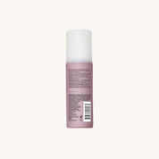 A pink bottle of Restore Repair Leave-In conditioner with a white cap stands upright against a plain light background. The back label displays text, a barcode, and product details about strengthening hair and preventing split ends.
