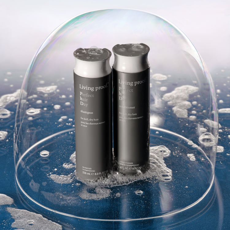 Two bottles of Perfect hair day Shampoo and Conditioner side by side in suds