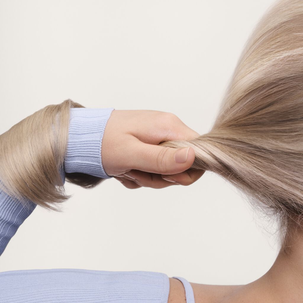 woman with holding her blonde hair