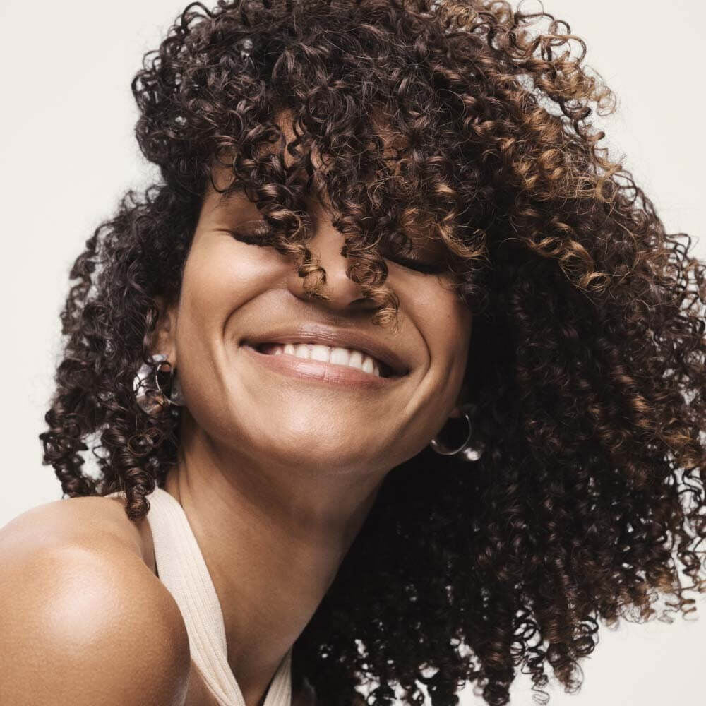 woman with curly hair smiling