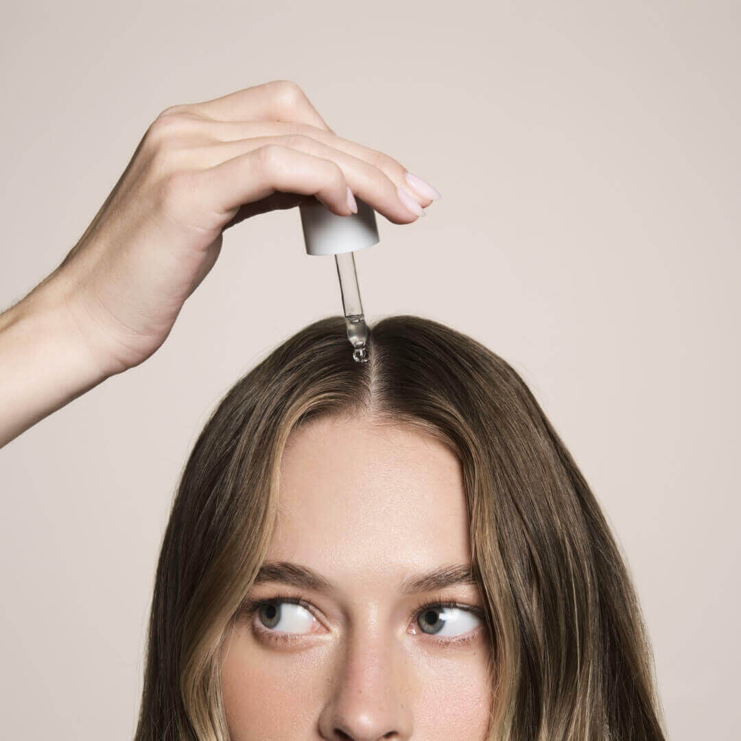 woman dropping product in her hair