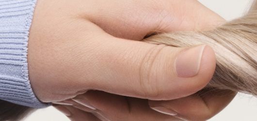 a hand grabbing blonde hair