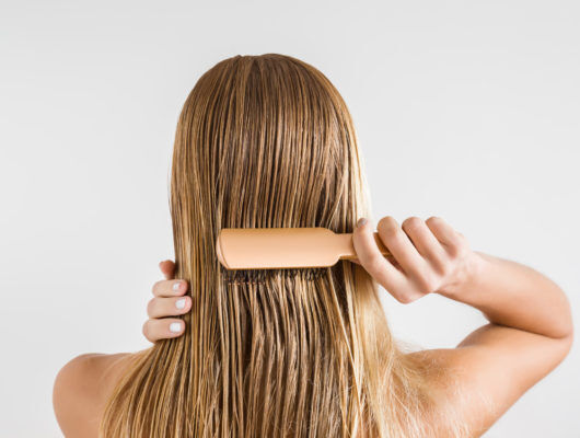 woman brushing wet hair