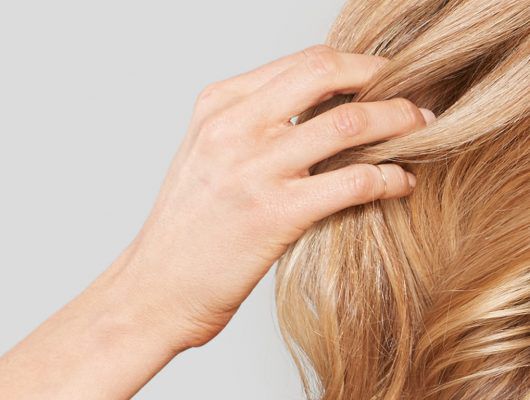 woman combing fingers through her blonde hair