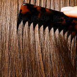 hand brushing hair with a comb close up 
