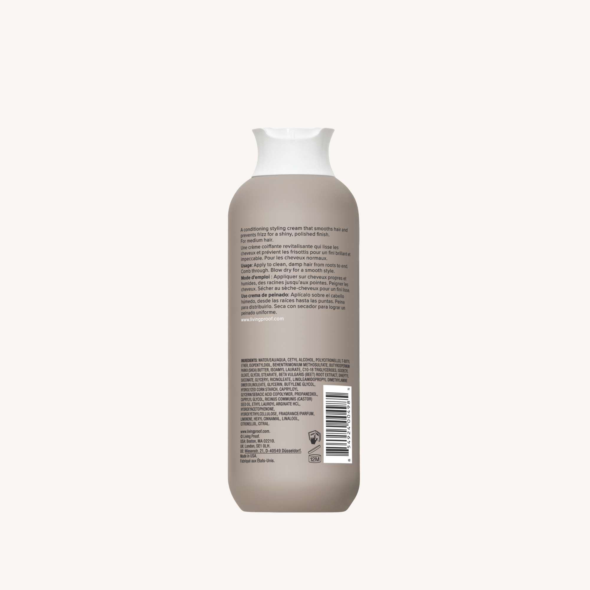 A beige bottle of No Frizz Smooth Styling Cream for medium hair with a white cap is shown from the back, featuring a label with frizz control benefits, ingredients, and a barcode. The background is plain off-white.