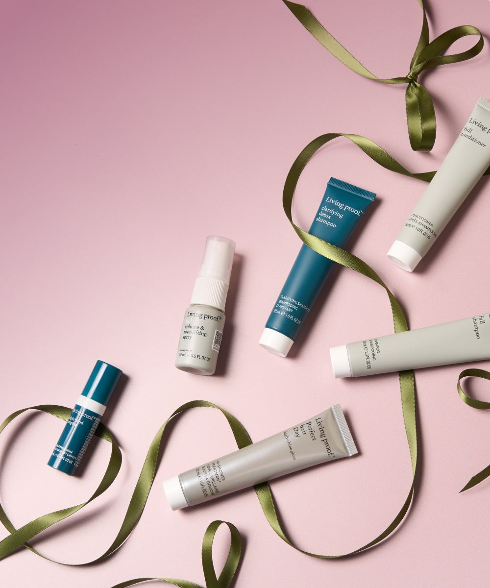 Haircare products with green ribbons on a pink background