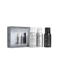 The Travel Essentials Set by Living Proof, featuring three hair products—Dry Volume &amp; Texture Spray, Advanced Clean Dry Shampoo, and shampoo—arranged beside the product box, which showcases images and details about the items.