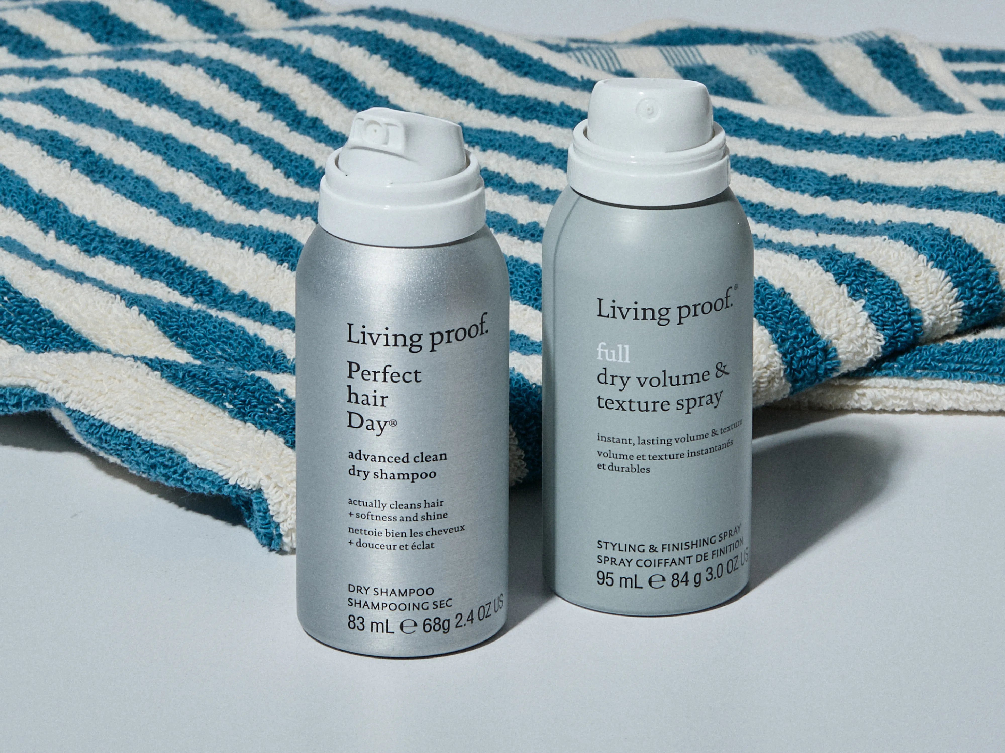 Two Living Proof hair care products on a striped towel