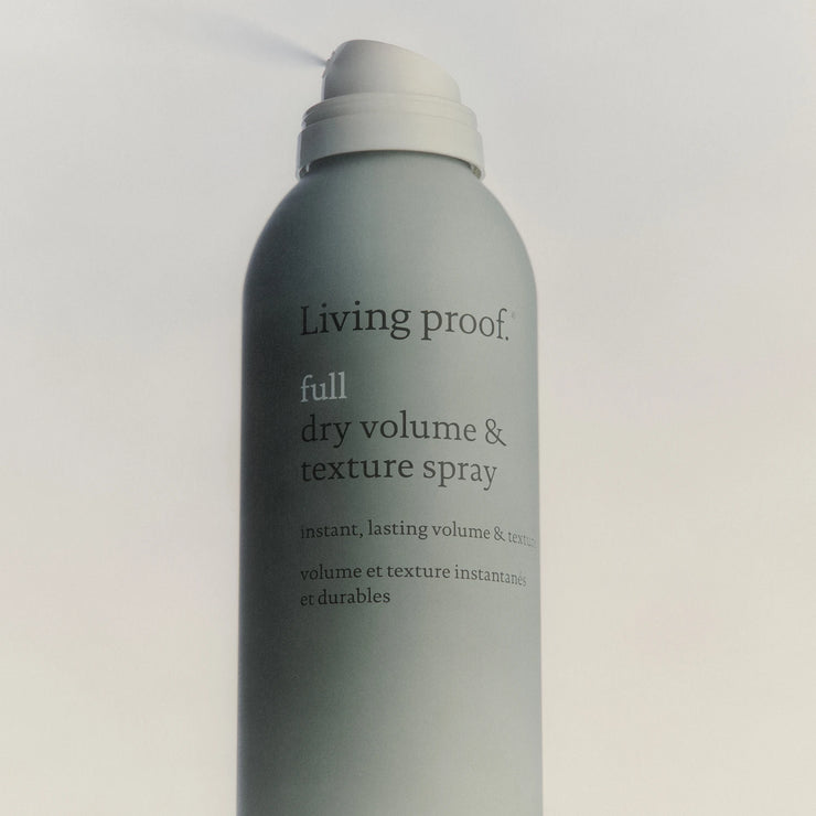 Living Proof hair spray bottle on a light gray background