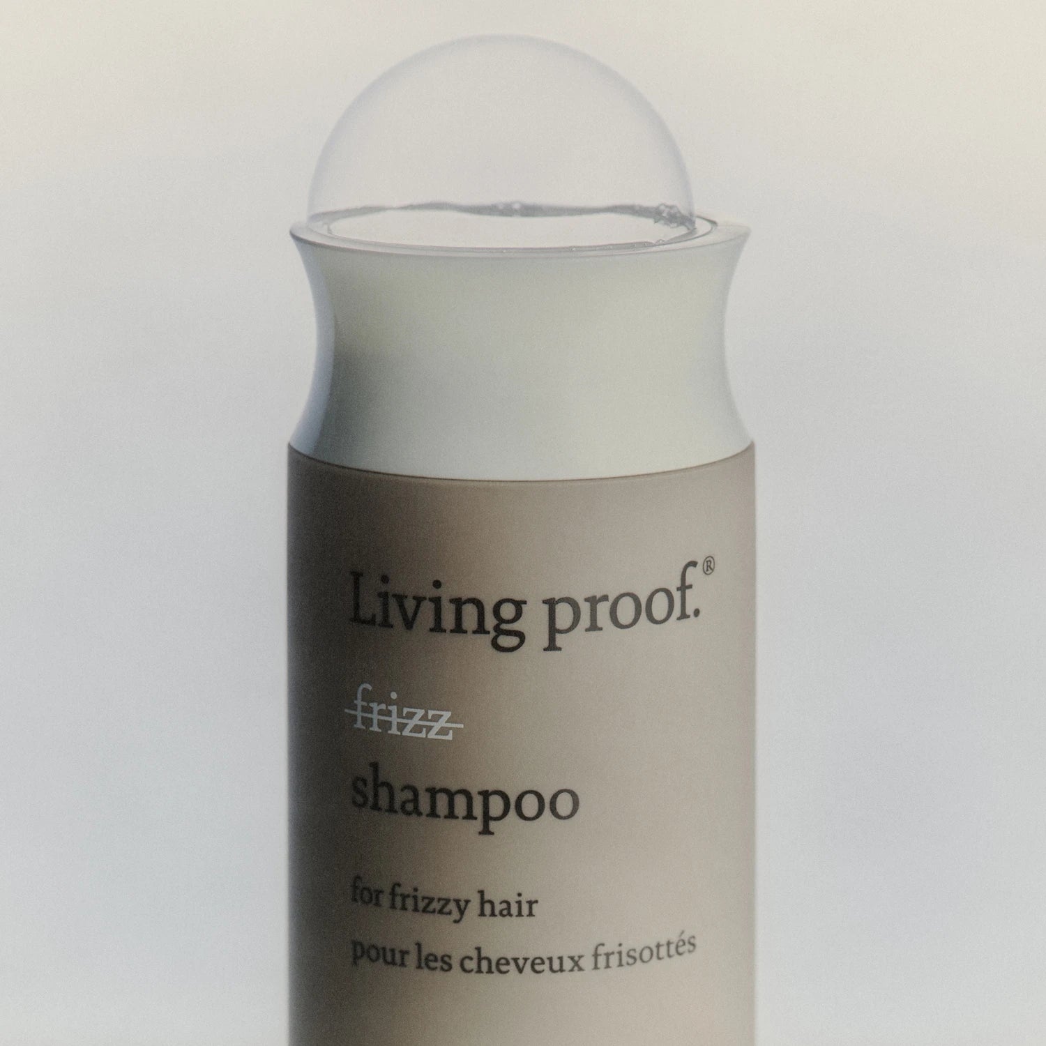Living Proof frizz shampoo bottle on a light gray background