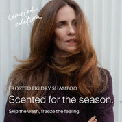 A woman with long brown hair stands in front of a light corrugated wall. Text reads: Limited-edition Perfect hair Day™ Frosted Fig Advanced Clean Dry Shampoo. Scented for the season. Skip the wash, freeze the feeling.