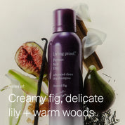 A limited-edition bottle of Perfect hair Day™ Frosted Fig Advanced Clean Dry Shampoo is surrounded by figs, white lilies, and wood. Text reads: Notes of: Creamy fig, delicate lily + warm woods.