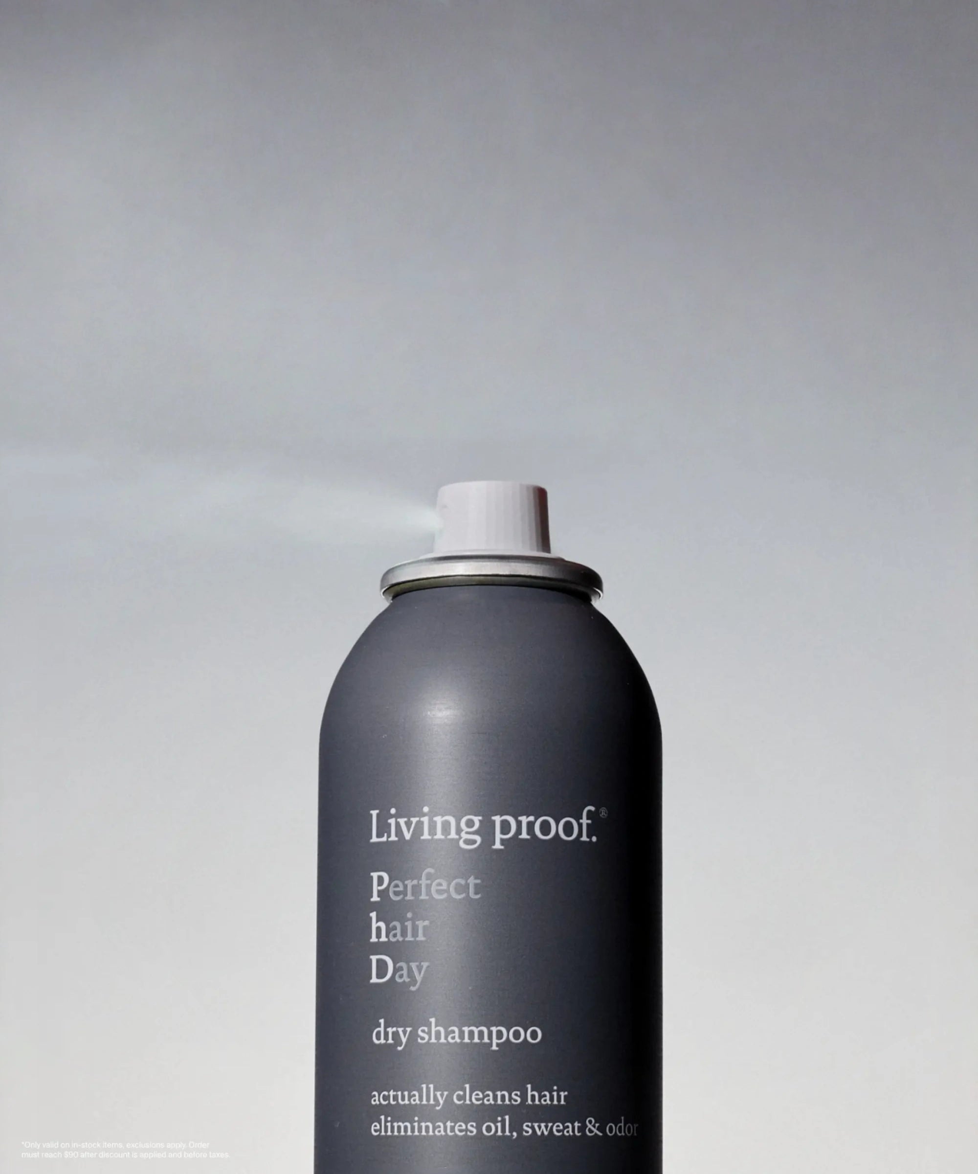Living Proof dry shampoo can on a gray background