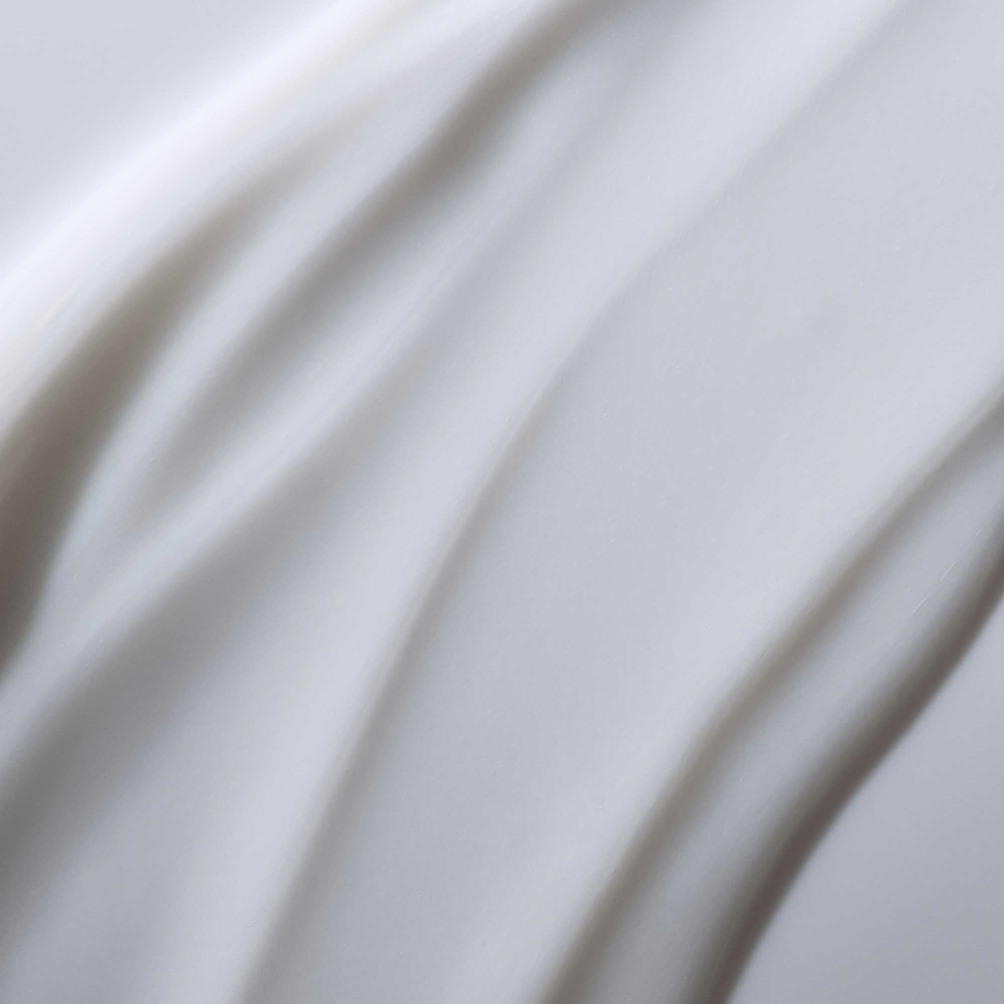 Close-up of smooth, flowing Full Conditioner with gentle curves and soft texture, forming an abstract, wavy pattern that suggests enhanced hair texture.