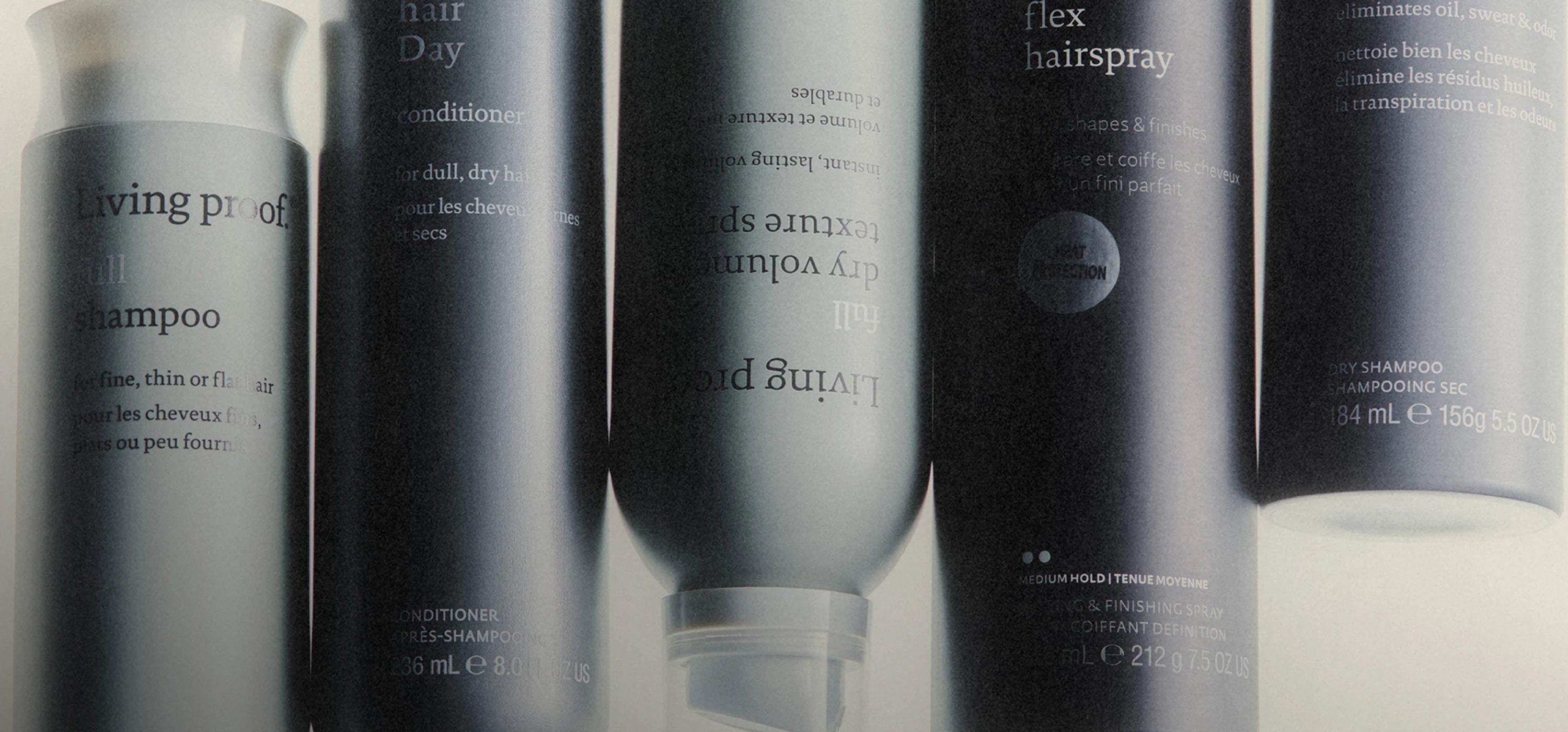 Collection of Living Proof hair care products on a reflective surface