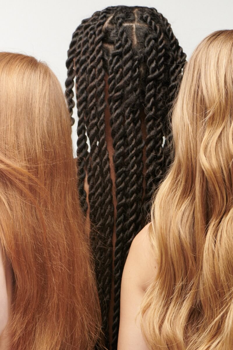 Three women with different hair styles on a plain background
