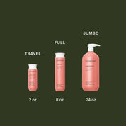 Three pink Living Proof Curl Conditioner bottles—travel (2 oz), full (8 oz), and jumbo (24 oz)—are arranged left to right on a dark green background. Ideal for detangling curls and keeping hair smooth, whatever the size.