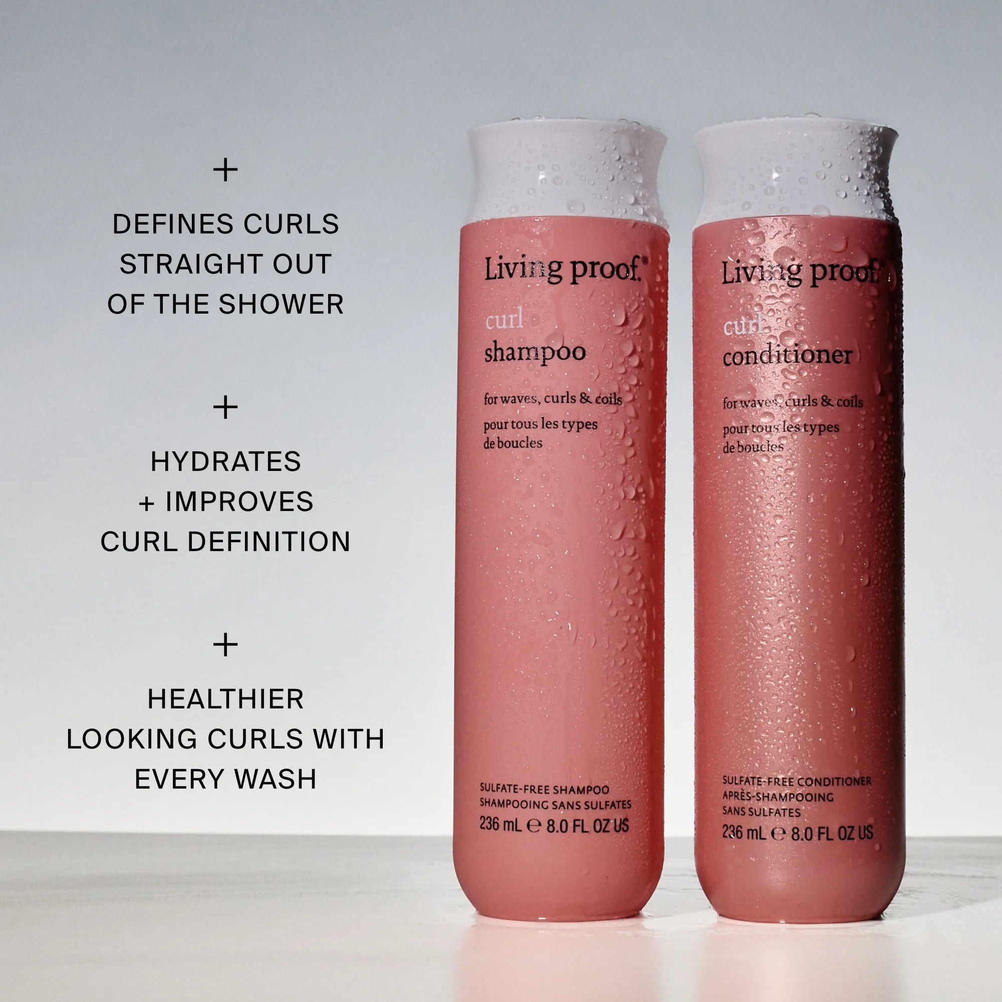 Two pink bottles of Living Proof Curl Shampoo stand upright with water droplets. Text highlights benefits: defines curls, hydrates, improves curl definition, and is silicone-free for healthier curls.