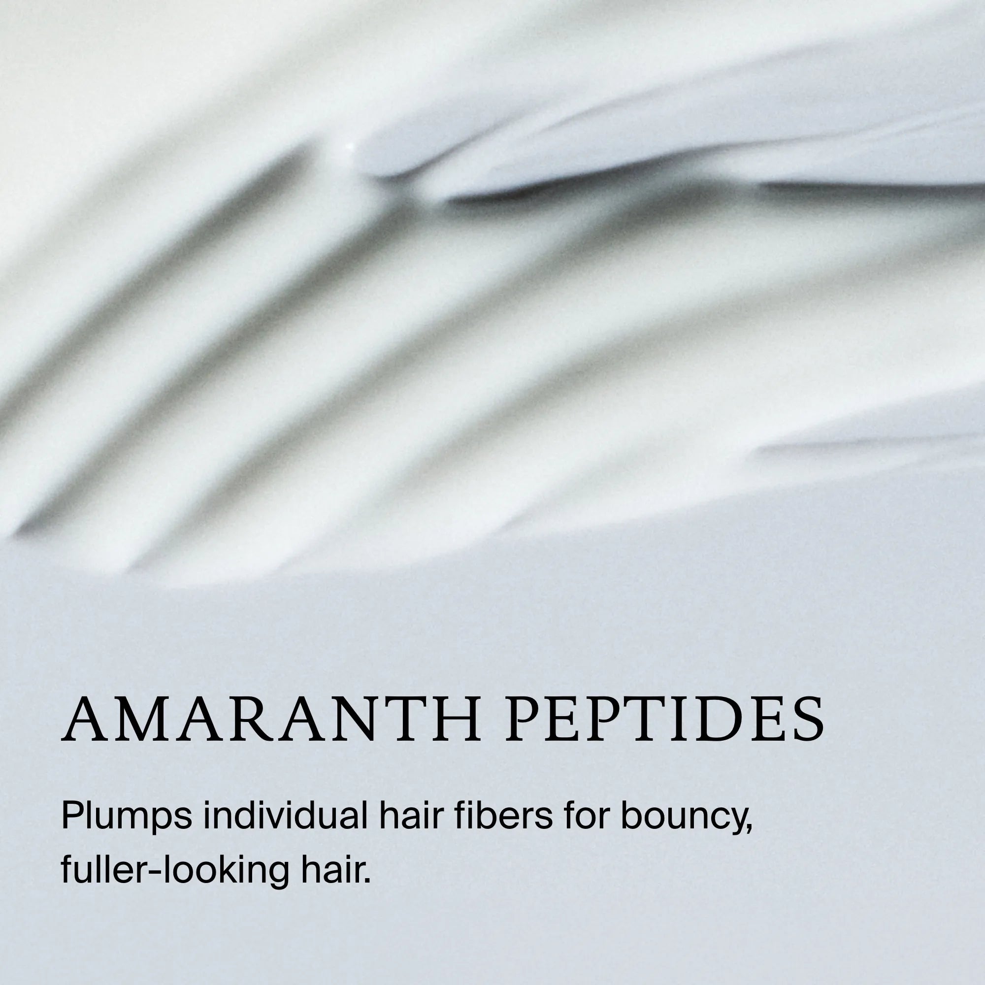 Close-up of Full Thickening Blow-Dry Cream, a creamy white formula with AMARANTH PEPTIDES. Plumps hair strands for bouncy, fuller-looking hair and adds heat protection. Soft pastel background.
