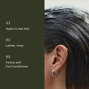 A close-up of someone with wet hair being shampooed with Full Shampoo, creating rich suds beside instructions: 1. Apply to wet hair. 2. Lather, rinse. 3. Follow with full conditioner. The person wears a silver hoop earring.