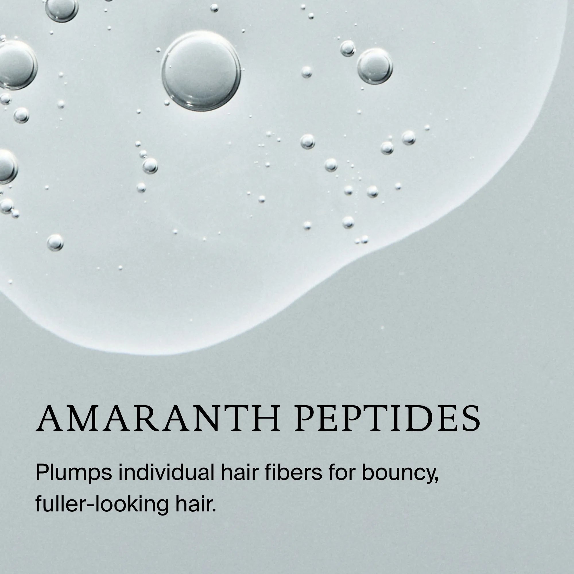 Close-up of clear liquid droplets on a light gray background, with text: Full Volume & Root-Lifting Spray. This invisible spray plumps individual hair fibers for bouncy, fuller-looking hair and provides heat protection.