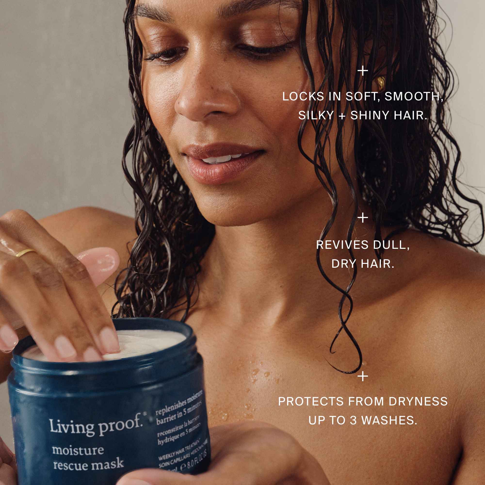Woman applying Living Proof moisture rescue mask to her hair with product details on a neutral background