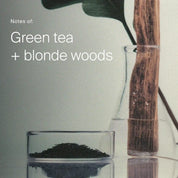 Glass container with green tea leaves and wooden spoon on a light background, with text 'Notes of: Green tea + blonde woods'.