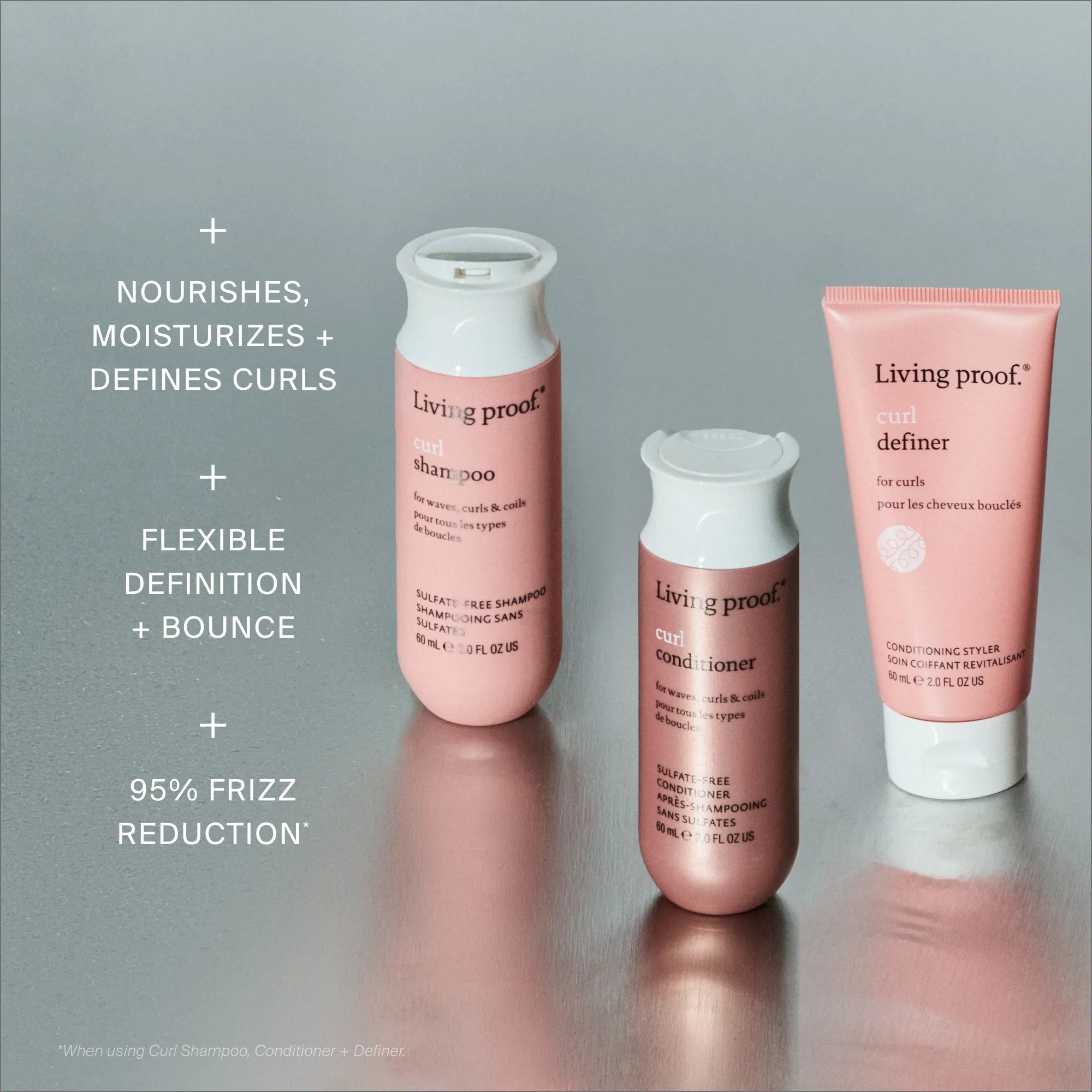 Three pink bottles of the Curl Definition + Moisture Set are arranged on a gray surface. Text highlights curl care benefits: nourishes curls, adds bounce, and delivers frizz-free curls with 95% less frizz.