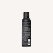 A black Style Lab® Flex Hairspray can with black cap, shown from the back with white text on the label, rests against a plain light background—ideal for touchable hair and medium hold to set your style.