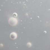 Translucent bubbles in a soft, light gray background evoke instant hydration and depth, reflecting the soothing, moisturizing benefits of Scalp Care Dry Scalp Treatment in this abstract and ethereal image.