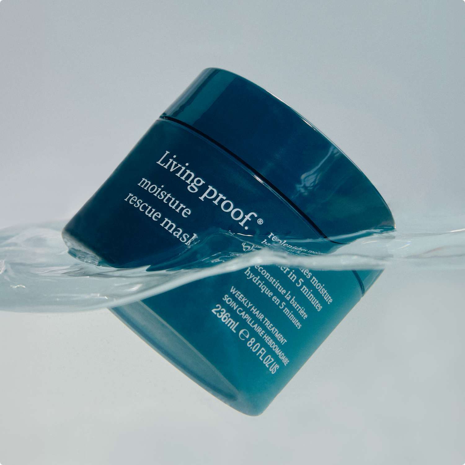 Living Proof moisture rescue masque jar with water effect on a light gray background