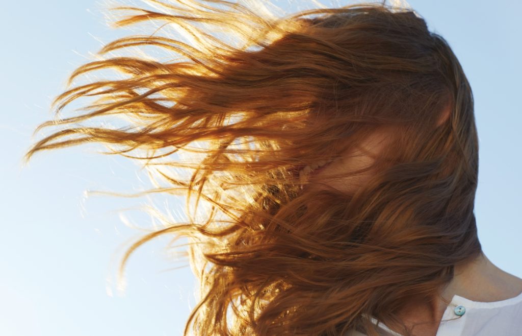 Woman with hair blowing in the wind.