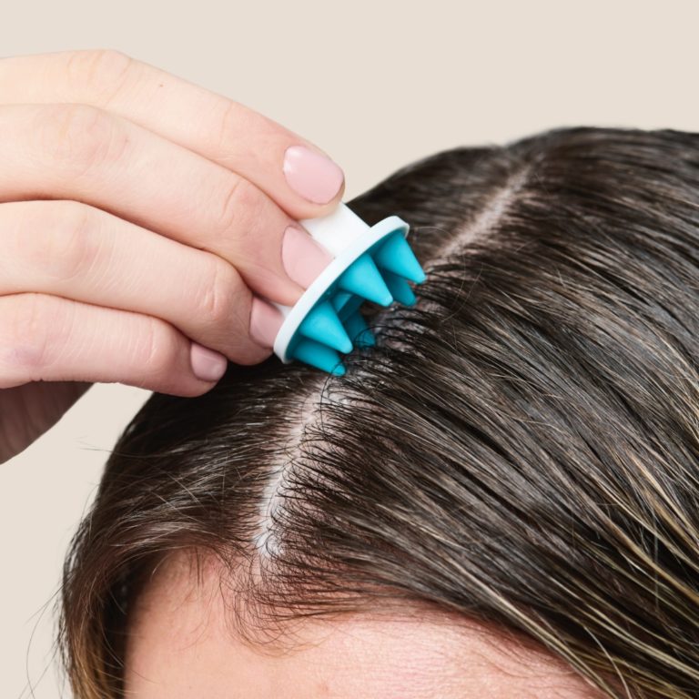 Woman applying a scalp treatment.