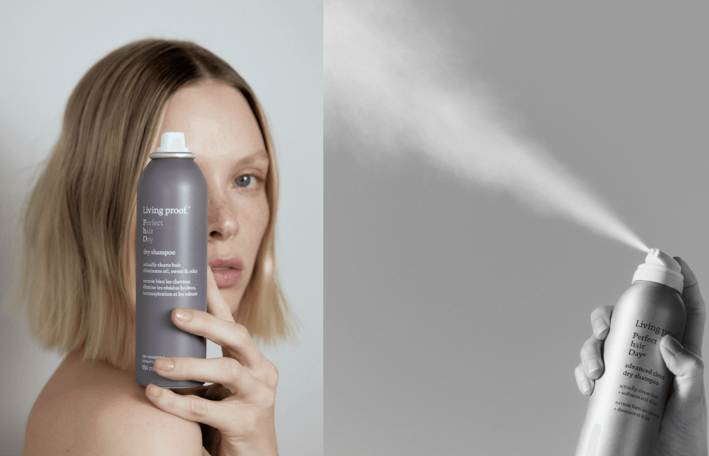 woman holding a can of dry shampoo and spraying it