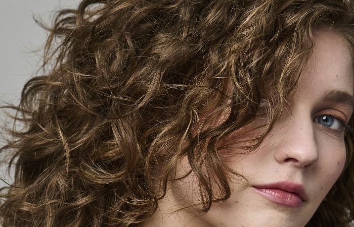 Woman with curly brown hair.