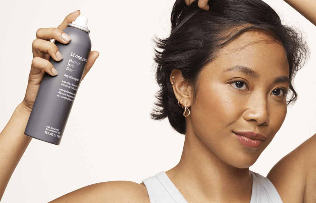 Image of a woman with short, dark hair applying Perfect hair Day™Dry Shampoo.