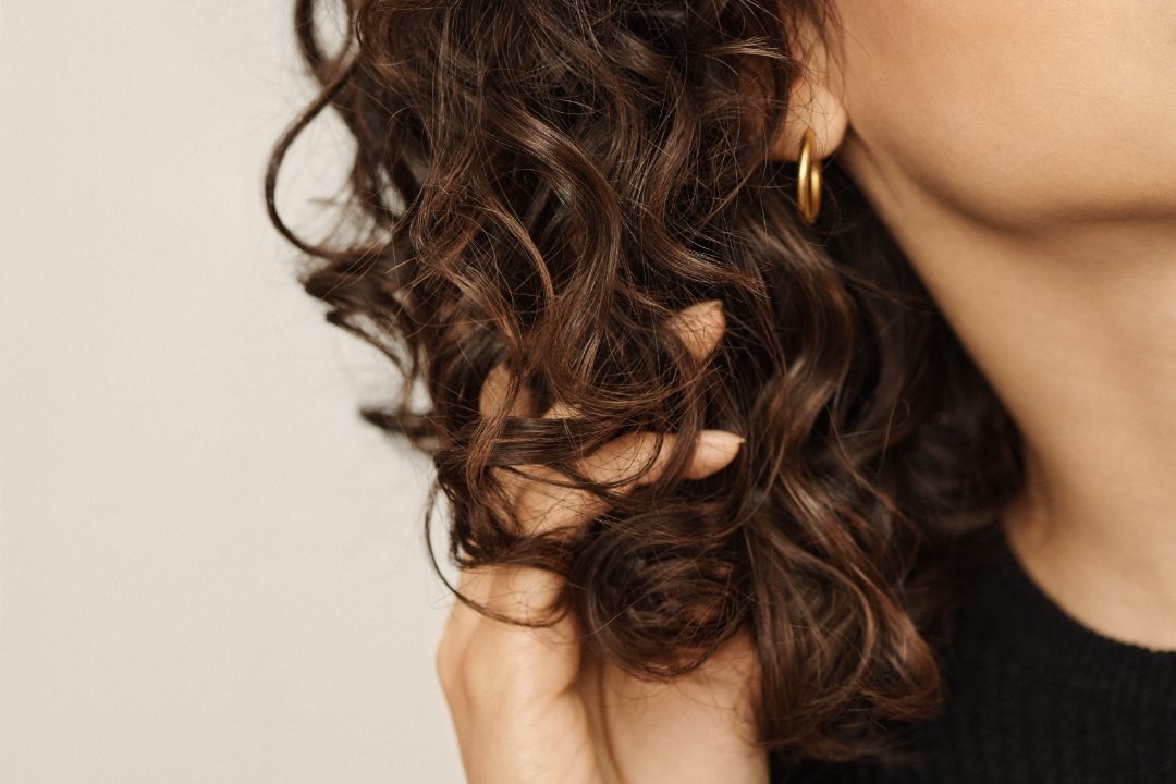 woman-running-fingers-through-curly-hair